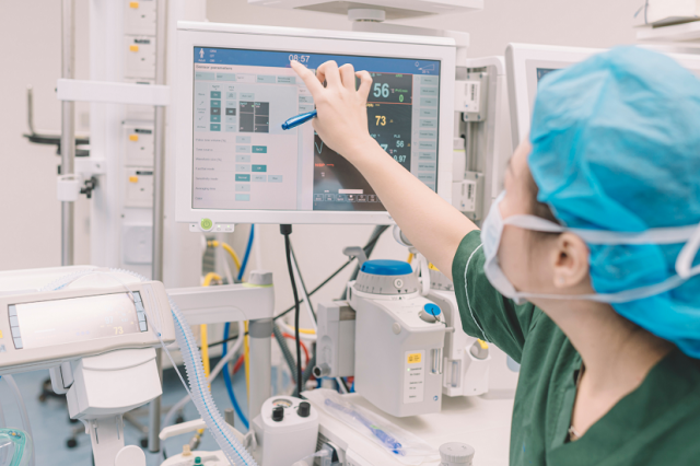 Anesthesiologist in the operating room using the surveillance monitor