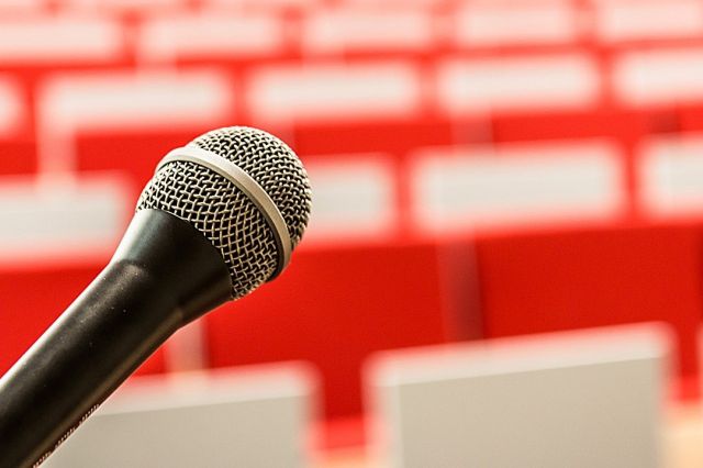 Microphone in front of empty chairs in a conference hall