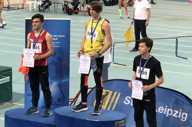 3 Schüler stehen auf dem Treppchen zur Siegerehrung, Silbermedaille für Luke Ortmann