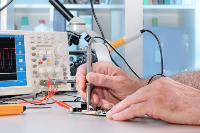 Engineer testing electronic components on PCB
