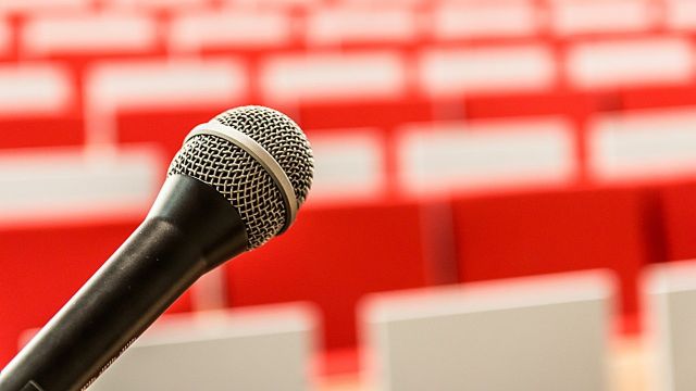 Microphone in front of empty chairs in a conference hall