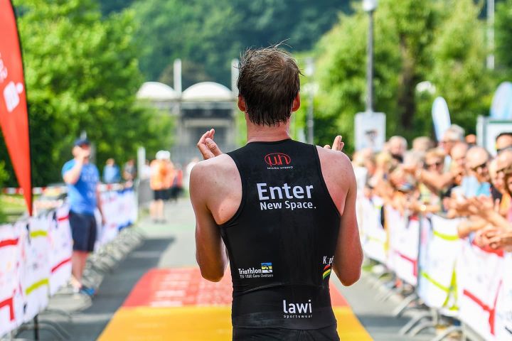 Triathlet Robin Schneider läuft durch Ziellinie