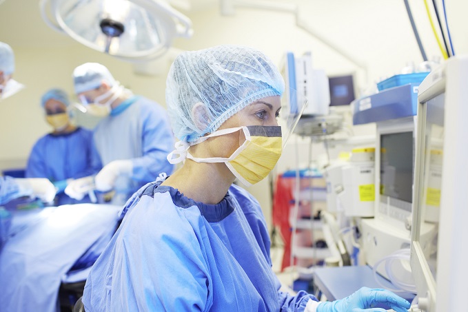 Anästhesistin im Operationsaal kontrolliert die Beatmung